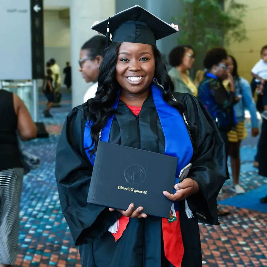 Herzing University Graduate Holding Diploma and Smiling