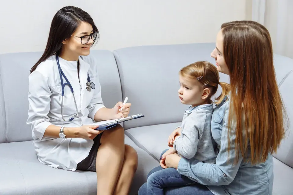 Pediatric Nurse Practitioner Smiling with Patient in Exam